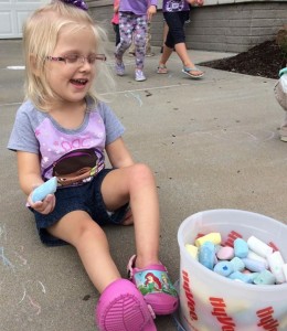 Emma loves playing with chalk outside.